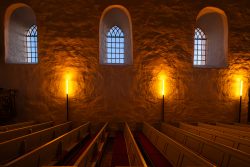 Insel Sylt Februar 2025 Einblick in eine historische Kirche, wo warmes Licht die Bänke und Fenster beleuchtet Insel Sylt Februar 2025 Historische Kirche mit beleuchteten Bänken und gotischen Fenstern