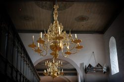 Insel Sylt Februar 2025 Ein eleganter goldener Kronleuchter in einer alten Kirche. Insel Sylt Februar 2025 Prächtiger Kronleuchter in einer historischen Kirche