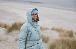 Insel Sylt Februar 2025 Eine Frau genießt einen kalten Tag am Strand Insel Sylt Februar 2025 Frau in blauer Jacke steht am Winterstrand mit Dünen