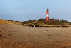 Insel Sylt Februar 2025 Ein roter Leuchtturm steht hoch zwischen den Dünen auf Sylt. Insel Sylt Februar 2025 Roter Leuchtturm in den Dünen von Sylt, Deutschland bei Tageslicht