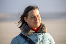 Insel Sylt Februar 2025 Eine Frau genießt die Strandatmosphäre Insel Sylt Februar 2025 Frau in blauer Jacke lächelt am Strand