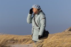 Insel Sylt Februar 2025 Eine Frau genießt einen klaren Tag in den Dünen. Insel Sylt Februar 2025 Frau in Winterkleidung blickt auf einer Dünenlandschaft