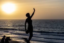 Insel Sylt Februar 2025 Eine eindrucksvolle Frauenskulptur wird von einem stimmungsvollen Sonnenuntergang am Strand eingerahmt Insel Sylt Februar 2025 Silhouette einer Frauenskulptur bei Sonnenuntergang am Strand