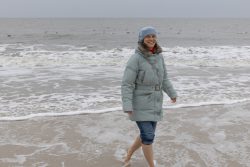 Insel Sylt Februar 2025 Eine Frau genießt einen kühlen Strandspaziergang im Winter Insel Sylt Februar 2025 Frau spaziert barfuß am Strand im Wintermantel