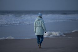Insel Sylt Februar 2025 Eine Person genießt einen ruhigen Wintertag am Meer Insel Sylt Februar 2025 Person in Winterjacke spaziert am kalten Strand entlang