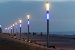 Insel Sylt Februar 2025 Menschen genießen einen Spaziergang entlang der Küste bei gedämpfter Beleuchtung Insel Sylt Februar 2025 Beleuchtete Promenade bei Dämmerung mit Spaziergängern und Meerblick