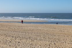 Insel Sylt Februar 2025 Menschen genießen einen erholsamen Spaziergang entlang des Sandstrandes am Meer Insel Sylt Februar 2025 Weitläufiger Sandstrand mit Spaziergängern am Meer bei blauem Himmel