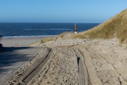 Insel Sylt Februar 2025 Reifenspuren im Sand führen zu einem malerischen Strand an der Nordsee. Insel Sylt Februar 2025 Strandweg mit Reifenspuren führt zum Nordseestrand bei klarem Himmel