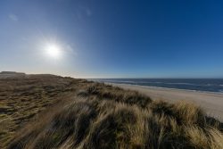 Insel Sylt Februar 2025 Ein ruhiger Strand bei Sonnenuntergang an der Nordsee Insel Sylt Februar 2025 Sonnenuntergang über einer Küstenlandschaft mit Dünen und Meer