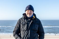 Insel Sylt Februar 2025 Ein Mann genießt die Aussicht auf das Meer bei kaltem Wetter Insel Sylt Februar 2025 Mann in schwarzer Jacke am Strand bei klarem Himmel