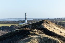 Insel Sylt Februar 2025 Ein Leuchtturm erhebt sich über den Sanddünen an der malerischen Küste Insel Sylt Februar 2025 Landschaft mit Leuchtturm und Sanddünen am Meer