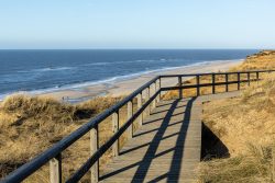 Insel Sylt Februar 2025 Ein Holzweg führt zu einem weitläufigen Strand an der Nordsee. Insel Sylt Februar 2025 Holzweg führt zu malerischem Strand an der Nordsee