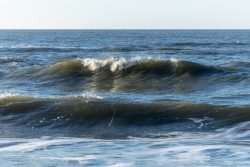 Insel Sylt Februar 2025 Die sanften Meereswellen brechen am Ufer. Insel Sylt Februar 2025 Wellen an einem sonnigen Tag auf dem Meer