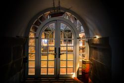 Insel Sylt Februar 2025 Eine kunstvoll gestaltete Holztür mit einem Modellschiff darüber in warmem Licht Insel Sylt Februar 2025 Historische Holztür mit Modellschiff in mystischem Licht