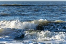 Insel Sylt Februar 2025 Sanfte Wellen rollen an einem sonnigen Tag ans Ufer Insel Sylt Februar 2025 Wellen am Meer mit blauem Himmel im Hintergrund