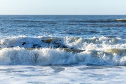 Insel Sylt Februar 2025 Schaumige Wellen brechen am Ufer bei einem ruhigen Sonnenuntergang. Insel Sylt Februar 2025 Wellen im Meer bei Sonnenuntergang
