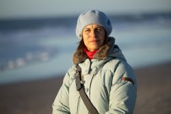 Insel Sylt Februar 2025 Eine Frau genießt den sonnigen Tag an einem ruhigen Strand Insel Sylt Februar 2025 Frau in blauer Jacke am sonnigen Strand