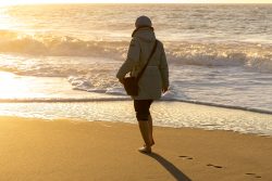 Insel Sylt Februar 2025 Eine Person genießt einen ruhigen Strandspaziergang im Winter bei Sonnenuntergang Insel Sylt Februar 2025 Person spaziert im Winter am Strand entlang, sonnenbeschienene Wellen im Hintergrund