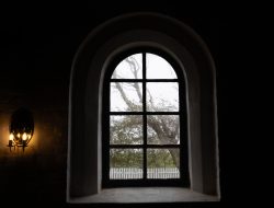 Insel Sylt und Hallig Hooge Oktober 2025 Ein rustikales Bogenfenster gibt den Blick auf einen kahlen Baum frei Insel Sylt und Hallig Hooge Oktober 2025 Bogenfenster mit Blick auf kahlen Baum und Lattenzaun