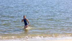 Insel Sylt und Hallig Hooge Oktober 2025 Eine Frau genießt einen entspannten Tag im Meer Insel Sylt und Hallig Hooge Oktober 2025 Frau im blauen Badeanzug läuft im Meer entlang