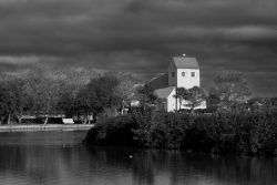 Insel Sylt und Hallig Hooge Oktober 2025 Ein markantes Kirchengebäude steht malerisch an einem ruhigen See Insel Sylt und Hallig Hooge Oktober 2025 Schwarz-Weiß-Foto einer Kirche am See unter dramatischem Himmel