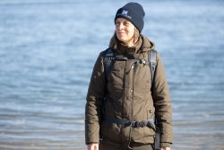 Insel Sylt und Hallig Hooge Oktober 2025 Eine Frau genießt den kühlen Tag am Strand Insel Sylt und Hallig Hooge Oktober 2025 Frau mit Mütze und Winterjacke am Strand stehend