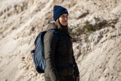 Insel Sylt und Hallig Hooge Oktober 2025 Eine Frau erkundet die Dünenlandschaft Insel Sylt und Hallig Hooge Oktober 2025 Frau mit Rucksack und Mütze steht auf sandigem Gelände