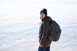Insel Sylt und Hallig Hooge Oktober 2025 Eine Person genießt einen sonnigen Tag am Strand in Winterkleidung Insel Sylt und Hallig Hooge Oktober 2025 Person in Winterkleidung mit Rucksack am sonnigen Strand