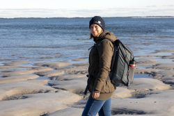 Insel Sylt und Hallig Hooge Oktober 2025 Eine Frau genießt einen Spaziergang am winterlichen Strand Insel Sylt und Hallig Hooge Oktober 2025 Frau bei kühlem Wetter am Sandstrand mit Rucksack