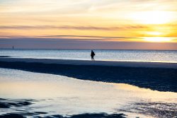 Insel Sylt und Hallig Hooge Oktober 2025 Eine ruhige Szene eines Spaziergangs bei Sonnenuntergang am Strand Insel Sylt und Hallig Hooge Oktober 2025 Person spaziert bei Sonnenuntergang an einem ruhigen Strand entlang