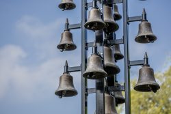 Keukenhof Niederlande April 2025 Ein Glockenturm mit mehreren Glocken an einem sonnigen Tag Keukenhof Niederlande April 2025 Mehrere Glocken an Metallgestell vor blauem Himmel