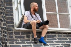 Lüneburg August 2024 Mann sitzt auf Fenstersims und hält Kamera