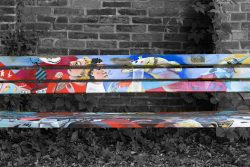 Lüneburger Heide August 2024 Bunt bemalte Bank vor Ziegelwand mit Pflanzenbewuchs