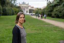 Padua Entschleunigte Fotografie Oktober 2024 Frau im Park mit Triumphbogen im Hintergrund