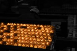 Mailand Entschleunigte Fotografie Oktober 2024 Kerzen leuchten in einer dunklen Kirche