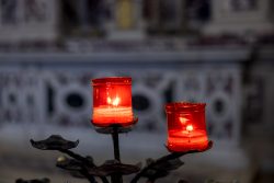 Padua Entschleunigte Fotografie Oktober 2024 Zwei rote Kerzen in einer Kirche, symbolisch für Gebete und Besinnung