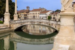 Padua Entschleunigte Fotografie Oktober 2024 Historische Brücke über einen Kanal in Padua mit Gebäuden im Hintergrund