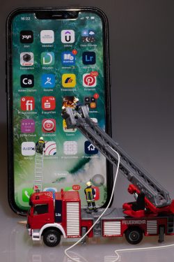 Tiny World Miniaturen Modulaufgabe OFG Online Schulung für Gestaltung Aloys Peter Trenz Spielzeug-Feuerwehrauto im Einsatz vor großem iPhone Tiny World Miniaturen Modulaufgabe OFG Online Schulung für Gestaltung Aloys Peter Trenz Modell-Feuerwehrauto rettet vor Smartphonebildschirm