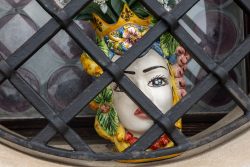 Venedig Entschleunigte Fotografie Oktober 2024 Keramikvase in Form eines Königsgesichts hinter Gitter