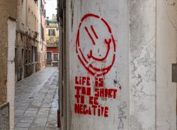 Venedig Entschleunigte Fotografie Oktober 2024 Rotes Graffiti mit Smiley und positiver Botschaft auf einer urbanen Wand