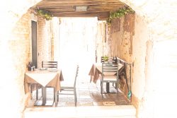 Venedig Entschleunigte Fotografie Oktober 2024 Gemütlicher Außenbereich eines Restaurants in einem charmanten, historischen Durchgang