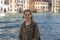 Venedig Entschleunigte Fotografie Oktober 2024 Frau steht vor Kanal in Venedig mit historischen Gebäuden im Hintergrund