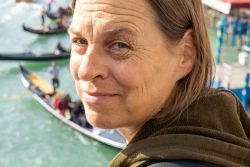 Venedig Entschleunigte Fotografie Oktober 2024 Lächelnde Person vor Gondeln auf dem venezianischen Kanal