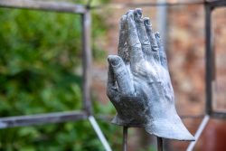 Venedig Entschleunigte Fotografie Oktober 2024 Betende Hände Skulptur im Freien mit grünem Hintergrund