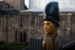 Bad Vilbel Herbst 2022 Fotoserie Aloys Peter Trenz Holzskulptur eines afrikanischen Kriegers vor unscharfer Burgkulisse