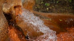 Bad Vilbel Herbst 2022 Fotoserie Aloys Peter Trenz Sprudelndes Mineralwasser fließt aus einer Quelle mit rostbraunem Gestein