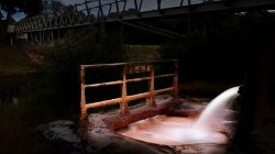 Bad Vilbel Herbst 2022 Fotoserie Aloys Peter Trenz Verrostete Brücke mit altem Wasserrohr in nächtlicher Landschaft