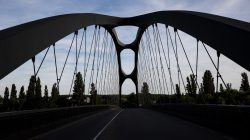 Brücken am Main - Fotoserie Aloys Peter Trenz Moderne Brücke mit einzigartigem Bogendesign und blauen Himmel im Hintergrund
