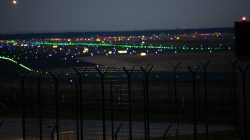 Frankfurt Airport Fotoserie Aloys Peter Trenz Nachtansicht eines beleuchteten Flughafenlandebahn mit farbigen Lichtern