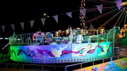 Fotografie Experimente mit Licht und Bewegung August 2022 Beleuchtetes Karussell und Riesenrad auf einem nächtlichen Jahrmarkt